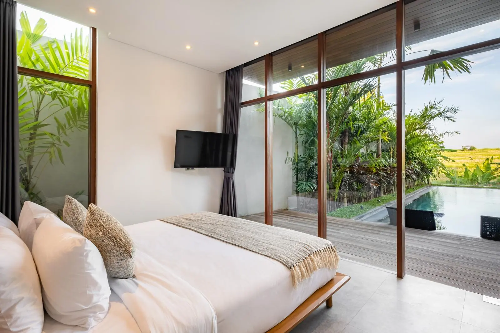 Ground-floor bedroom opening onto the pool deck River Paradise 4BR Pererenan Bali