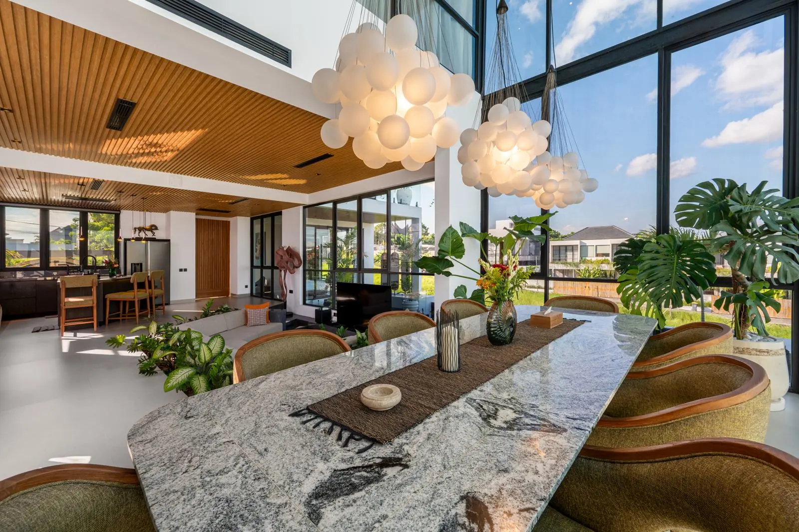 Dining table beneath globe pendants in the double-height living room MAR Bali 1 Pererenan Bali